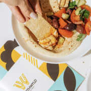 Close-up of Mediterranean shareable plate with pita, hummus, and olives at Worthwyld Happy Hour